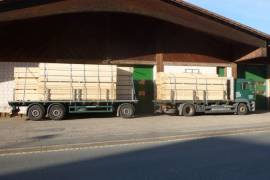Zwei LKW mit Schnittholz vor der Halle