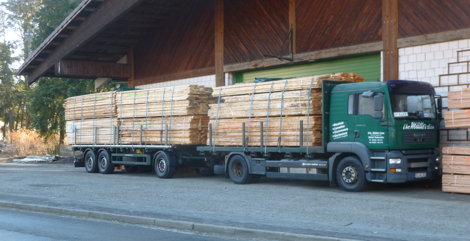 LKW mit Holzladung vor der Halle des Sägewerks